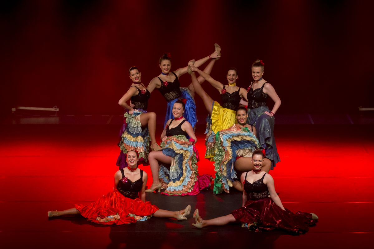 Dansgroep tijdens een optreden op een rood verlicht podium